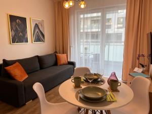 a living room with a couch and a table and chairs at Apartament Fordon Przy Politechnice Bydgoskiej in Bydgoszcz
