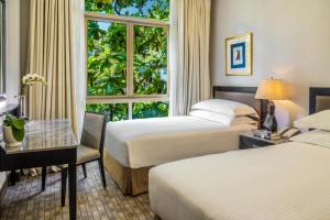 a hotel room with two beds and a window at Treetops Executive Residences in Singapore