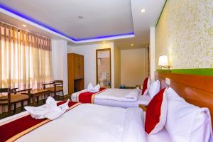 Habitación de hotel con 3 camas y mesa en Hotel Sekai, en Katmandú