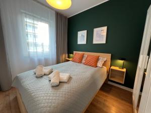 a bedroom with a bed with two towels on it at Apartament Fordon Przy Politechnice Bydgoskiej in Bydgoszcz