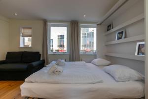 1 cama blanca grande en una habitación con ventanas en Welcome in - Appartement midden in het centrum met dakterras, en Vlissingen
