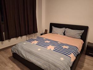 una camera con un letto e un piumone blu e bianco di Cazare Regim Hotelier apartament 2 camere Militari a Roşu