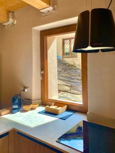 een keuken met een raam en een aanrecht bij Courmayeur Superior Suite by SupaStays in Courmayeur