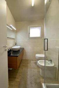 baño con lavabo y aseo y ventana en House on the river Arno, en Ellera