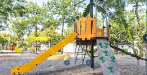 a playground with a yellow slide at a park at Mobile home 6 places camping 5 Vacances Gorges de lArdeche in Lagorce