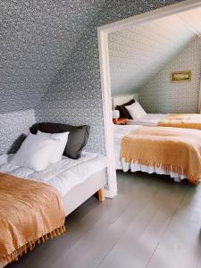 a bedroom with two beds and a mirror at Skrea Backe Bo in Falkenberg