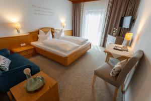 a hotel room with a bed and a couch at Pension Zirbenhof in Ramsau am Dachstein