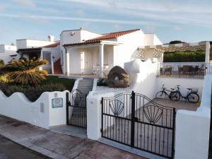 uma casa branca com um portão e uma cerca em Casa Su Soli Sardu II - Sea View em Codaruina