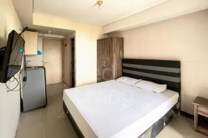 ein Schlafzimmer mit einem großen weißen Bett in einem Zimmer in der Unterkunft RedLiving 19 Avenue Apartment by RH Room in Tangerang