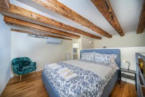 um quarto com uma cama azul e uma cadeira em Chic Retreat em Trieste