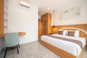 a bedroom with a large bed and a chair at Sunny Village Berawa in Canggu