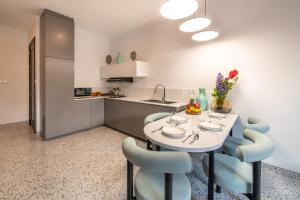 a kitchen with a white table and blue chairs at Sunny Village Berawa in Canggu