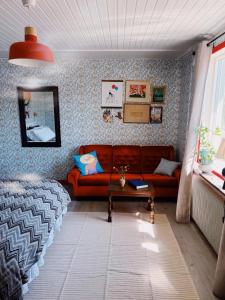 a living room with a red couch and a table at Skrea Backe Bo in Falkenberg