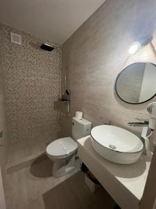a bathroom with a toilet and a sink and a mirror at Ama Boutique in Constanţa