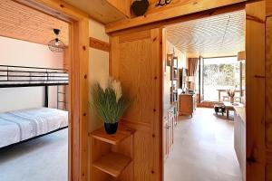een slaapkamer met een bed in een houten huis bij Le Cocoøn - Appt vue montagne in La Bresse