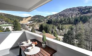 een balkon met 2 tafels en uitzicht op een berg bij Le Cocoøn - Appt vue montagne in La Bresse