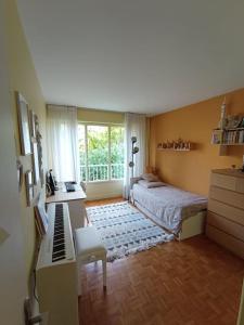 Schlafzimmer mit einem Bett, einem Schreibtisch und einem Fenster in der Unterkunft Appartement 6 personnes 100 m2 in Chatou