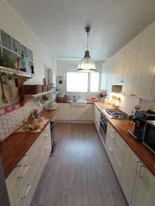 eine große Küche mit weißen Schränken und Holzböden in der Unterkunft Appartement 6 personnes 100 m2 in Chatou