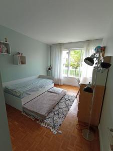 Schlafzimmer mit einem Bett, einem Fenster und einem Teppich in der Unterkunft Appartement 6 personnes 100 m2 in Chatou