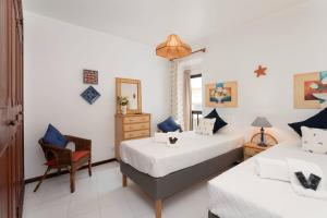 1 dormitorio con 2 camas y 1 silla en Great, Bright 2-bedroom Flat in the Center of Vilamoura -Topázio By Centralgarve, en Vilamoura