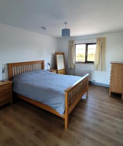 Un dormitorio con una cama grande y una ventana en Roaringwater Stay, en Skibbereen
