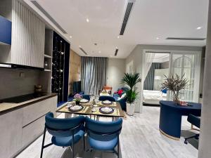 Il dispose d'une cuisine et d'un salon avec une table et des chaises bleues. dans l'établissement Kaida Apartment (凯达公寓酒店), à Bắc Ninh