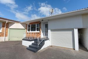 a house with a garage door and a porch at Auckland Airport apartment in Auckland