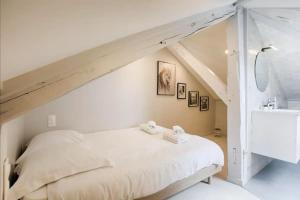 um quarto com uma cama branca num sótão em Mermoz/Deauville : Superbe Appartement em Deauville