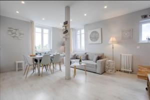 uma sala de estar branca com uma mesa e um sofá em Mermoz/Deauville : Superbe Appartement em Deauville