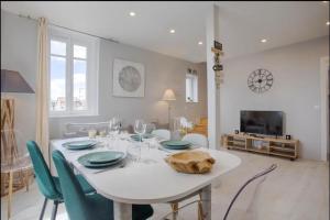uma sala de jantar branca com uma mesa e cadeiras brancas em Mermoz/Deauville : Superbe Appartement em Deauville