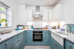 a kitchen with blue cabinets and a sink at Lilliput Hideaway 5 mins from Sandbanks Beach in Parkstone