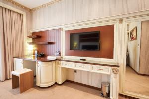 a hotel room with a desk with a television on a wall at Boulevard Side Hotel in Baku