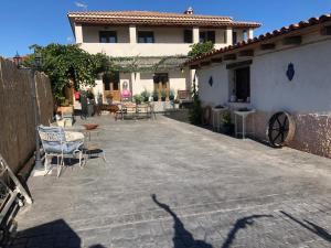 un patio con sillas y mesas frente a una casa en Los Diezmos, en Torremocha de Jarama