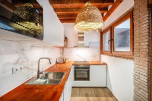 kuchnia z białymi szafkami i zlewem w obiekcie Touch My Heart Malaga City center apartment BY NAMASTE ELITE w Maladze