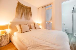 sypialnia z dużym białym łóżkiem i oknem w obiekcie Touch My Heart Malaga City center apartment BY NAMASTE ELITE w Maladze
