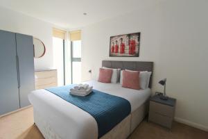 um quarto com uma cama grande e um cobertor azul em Tooley Street Apartments by Viridian Apartments em Londres