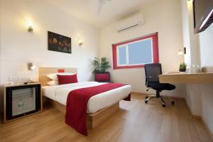 Dormitorio con cama, escritorio y TV en Red Fox Hotel, East Delhi, en Nueva Delhi