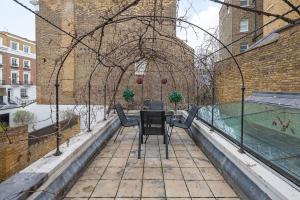 d'une terrasse avec une table et des chaises sur un balcon. dans l'établissement Casa Italia near Sloane Square - AC all Bedrooms, à Londres