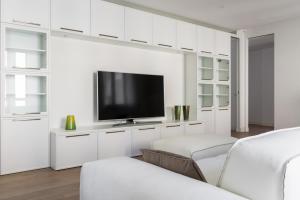 een woonkamer met witte kasten en een flatscreen-tv bij Pure White - by MyHomeInComo in Como