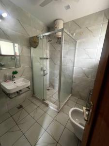a white bathroom with a shower and a sink at Kamz Homestay Chandigarh 35 in Chandīgarh