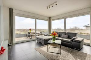 un soggiorno con un divano e un tavolo di Karthuizer Penthouse a Nieuwpoort