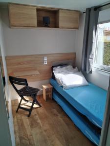 Кровать или кровати в номере Bungalow tout confort camping siblu les charmettes
