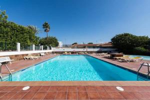 a large swimming pool with blue water at Bungalow Ubicación Ideal in San Bartolomé de Tirajana