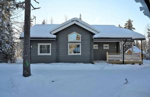 dom ze śniegiem na dachu w obiekcie Arctic Home Experience w mieście Äkäslompolo