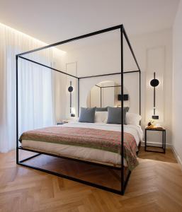 1 dormitorio con 1 cama grande con dosel de cristal en Maia Flora Taormina Apartments, en Taormina