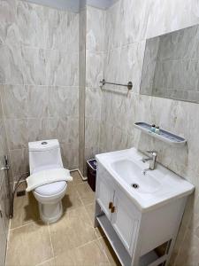 a bathroom with a white toilet and a sink at Luna hotel in Ban Ko