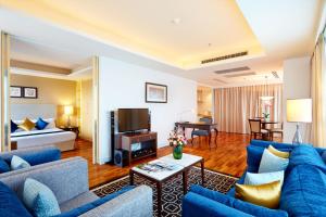 een woonkamer met blauwe meubels in een hotelkamer bij The Duchess Hotel in Bangkok