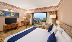 a hotel room with a bed and a television at Mövenpick Resort Aswan in Aswan