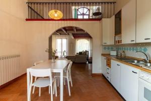 a kitchen with a table and chairs in a room at Su Trigu, primo piano in Bari Sardo