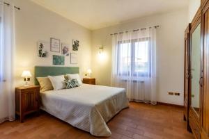 Un dormitorio con una cama grande y una ventana en Su Trigu, primo piano, en Bari Sardo